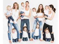 a group of women and children posing for a photo with their arms around each other