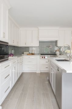 a kitchen with white cabinets and wood flooring is pictured in this image from the front view