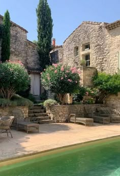 an outdoor swimming pool surrounded by stone buildings