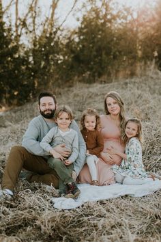 a family sitting on a blanket in the grass