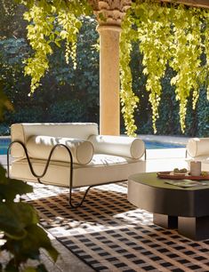 a living room with two couches and a coffee table in front of a pool