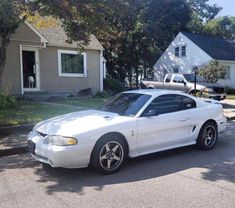 a white car parked in front of a house