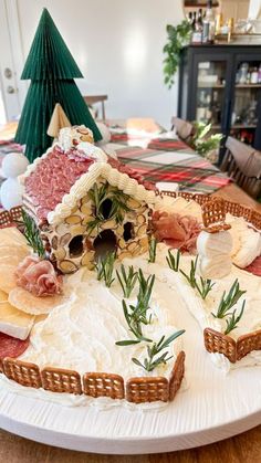 a platter filled with meat and cheeses on top of a table next to a christmas tree