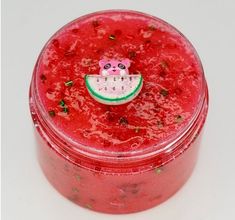 there is a small container that has watermelon on it and a pink bear in the center