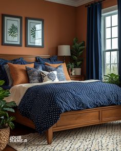 a bedroom with blue and orange bedding, potted plants, and two framed pictures on the wall