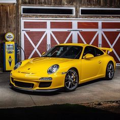 a yellow sports car parked in front of a garage