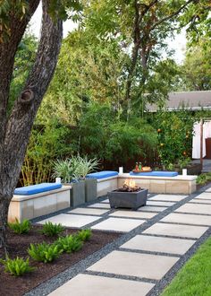 an outdoor patio and fire pit surrounded by trees