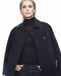 a woman is wearing a peael coat and black turtle - neck sweater with jeans