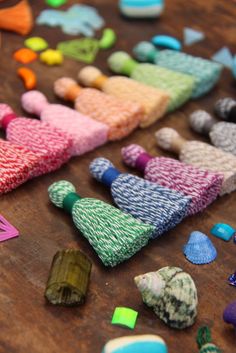 many different colored pieces of fabric on a wooden table with scissors and other items around them