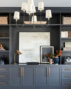 a living room with gray cabinets and white lamps