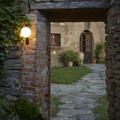 an open door leading to a stone building with a light on it's side