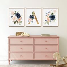 two paintings on the wall above a pink dresser