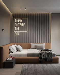 a bed sitting in the middle of a bedroom next to a wall mounted sign that says think outside the box