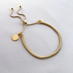 "Put your stamp on our gorgeous yellow gold vermeil snake bracelet and stack them up for a statement look!  Our yellow gold mini disc charm measures 8x8mm, perfectly sized for initials. The yellow gold disc sits on a sterling silver snake slider bracelet, which can be adjusted from 4.5\" to 9.5\" to fit most adult wrists perfectly.  Our yellow gold vermeil jewellery is made with genuine .925 sterling silver which has been expertly plated with a yellow gold layer.  Presented on your choice of bea Adjustable Tarnish Resistant Gold Snake Chain Bracelet, Minimalist Adjustable Yellow Gold Charm Bracelet, Adjustable Minimalist Yellow Gold Charm Bracelet, Adjustable Gold Snake Chain Bracelet, Adjustable Yellow Gold Snake Chain Bracelet, Gold Engraved Minimalist Charm Bracelet, Adjustable Snake Chain Gold Bracelet For Everyday, Adjustable Snake Chain Gold Bracelet Gift, Silver Quotes