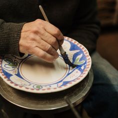 a man is cutting into a plate with a knife and fork on top of it