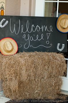 a welcome sign with straw bales and cowboy hats on the front door sill