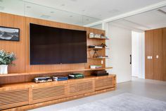 a large flat screen tv mounted to the side of a wooden wall