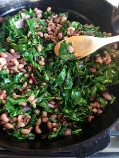 spinach and beans are being cooked in a skillet