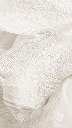 an abstract photo of white fabric with wavy lines in the middle and one line at the bottom