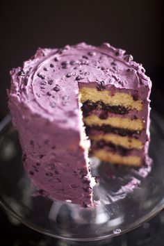 a cake that has been cut in half and is on a glass plate with one slice taken out