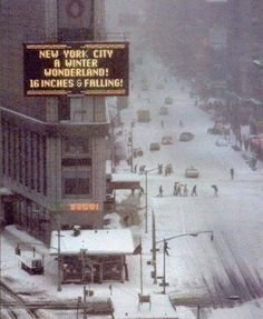 a city street is covered in snow as traffic moves through the streets on a snowy day