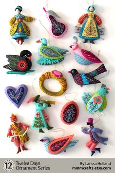 some ornaments are hanging on the wall in different colors and shapes, including birds, flowers, and hearts