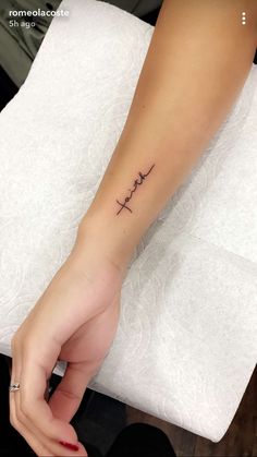 a woman's arm with a small cross tattoo on it, and the word hope written