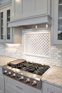 a stove top oven sitting inside of a kitchen next to white cabinets and counter tops