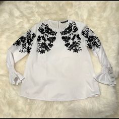 Zara- White Bell Sleeves White Shirt With Black Sequin And Velvet Embroidery Xs. Nwt- This Classic White Shirt Is Taken To Another Level With The Exquisite Black Pattern Of Flowers And Leaves That Is Embellished With Subtle Sequins And Velvet Fabric. The Bell Sleeves Top It Off. Elegant Blouse From Start To Finish. White Embroidered Long Sleeve Top, White Crew Neck Blouse With Floral Embroidery, White Long Sleeve Top With Embroidered Hem, White Long Sleeve Blouse With Embroidered Hem, Chic White Embroidered Blouse, Zara Black Tops With Floral Embroidery, Zara Black Embroidered Tops, White Long Sleeve Tops With Floral Embroidery, Chic White Blouse With Embroidered Sleeves