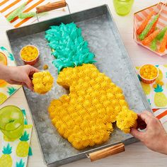 someone is decorating a pineapple cake on a tray