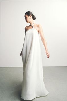 This dress is a luxurious and stylish piece. With flared, twisted shoulder straps and an A-line silhouette, this dress is perfect for any special occasion. Crafted from soft and lightweight silk, it will flatter your figure with a contemporary touch. Be the center of attention and look fabulous in this beautiful maxi dress. White Dress Editorial, Minimalist Bridesmaid Dress, Modern White Dress, Loose Wedding Dress, Loose Gown, Maxi Silk Dress, Wedding Sweater, Minimalist Gown, Bridal Shrug