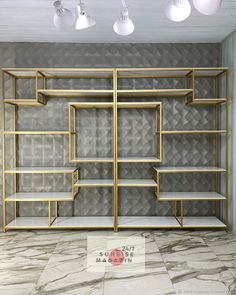 an empty room with gold shelves and lights