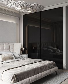 a large white bed sitting in a bedroom next to a black wall and a chandelier