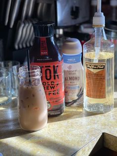 the bottles are lined up on the table with drinks in them and one is empty