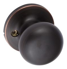 two round knobs on an antique style door handle, one black and the other bronze