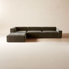 a large gray couch sitting on top of a floor next to a white wall in a living room