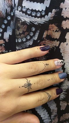 two fingers with tattoos on them, one has an arrow and the other has flowers