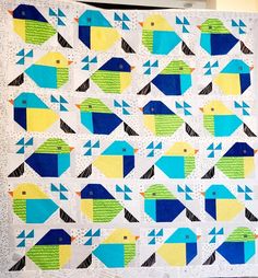 a quilt made with blue, yellow and green birds