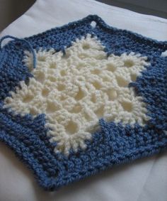 a blue and white crocheted dishcloth on a bed