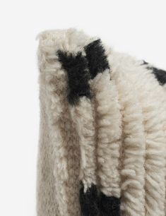 a black and white cow sweater hanging on a wall