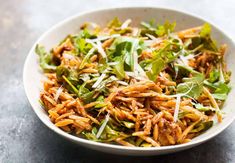 a white bowl filled with lots of green food