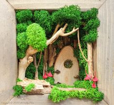 an image of a miniature garden in the shape of a hobbot door with trees and flowers