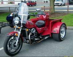 a red motorcycle is parked in a parking lot