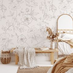 a bed room with a neatly made bed and flowers on the wall next to it