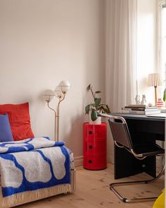 a bedroom with a bed, desk and chair in it next to a large window