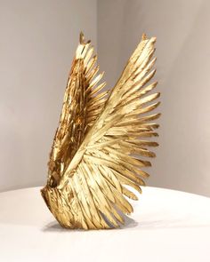 a golden bird sculpture sitting on top of a white table