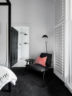 a black and white bedroom with pink pillows