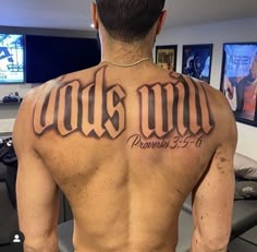 the back of a man's upper body with his name tattooed on it,