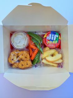 an open box filled with assorted snacks and toppings on top of each other