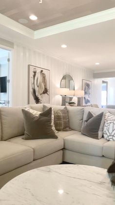 a living room filled with lots of furniture and pillows on top of a white table